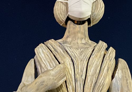 Assembled Wake Sculpture wearing a face mask